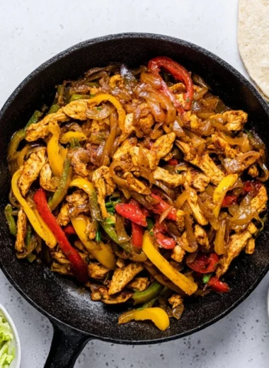 Delicious Chicken Fajitas with colorful peppers and onions served in a skillet.