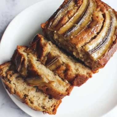 Loaf of classic banana bread with slices on a wooden cutting board
