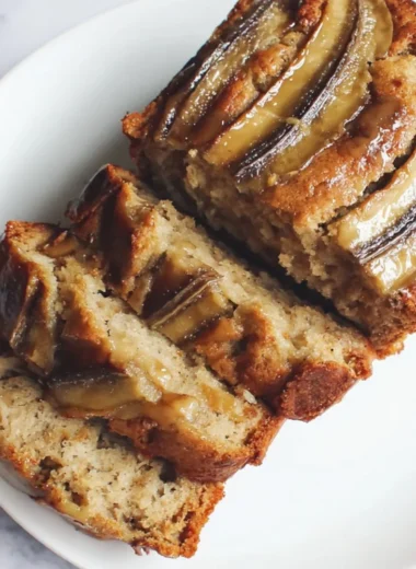 Loaf of classic banana bread with slices on a wooden cutting board