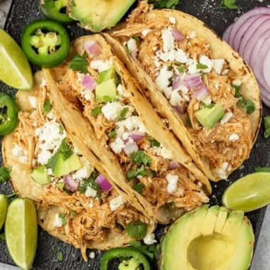 Crockpot Chicken Tacos served on a plate with fresh toppings