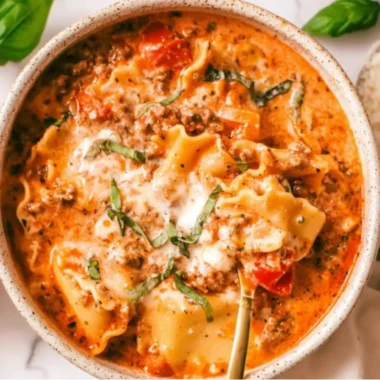 Bowl of creamy lasagna soup with cheese and fresh herbs ready to be served