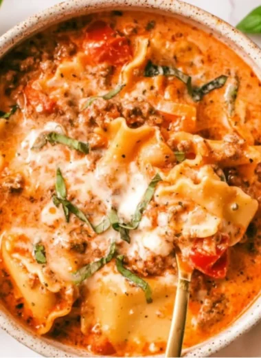 Bowl of creamy lasagna soup with cheese and fresh herbs ready to be served