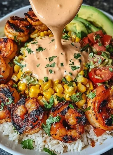 Grilled shrimp bowl with avocado, corn salsa, and creamy sauce.