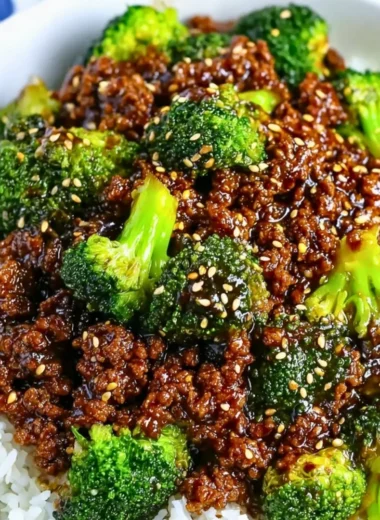 A plate of ground beef and broccoli stir-fry served with rice.