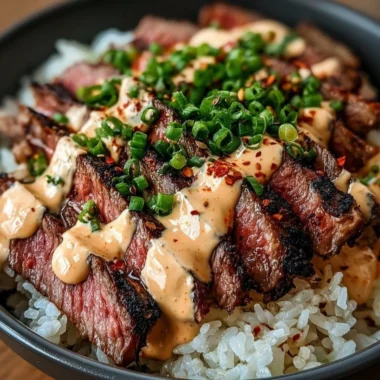 Korean BBQ steak rice bowl topped with fresh vegetables and sauce