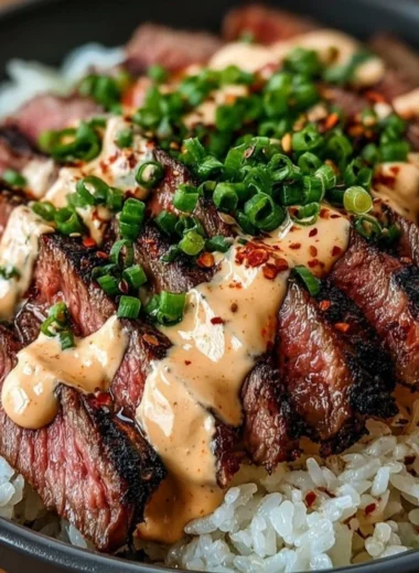 Korean BBQ steak rice bowl topped with fresh vegetables and sauce