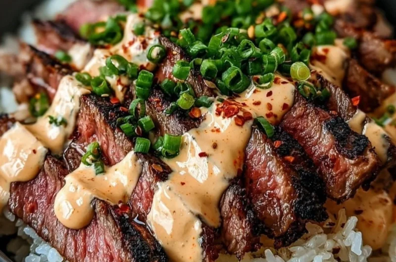 Korean BBQ steak rice bowl topped with fresh vegetables and sauce