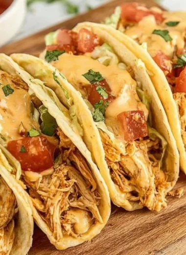 Delicious Slow Cooker Queso Chicken Tacos garnished with fresh cilantro