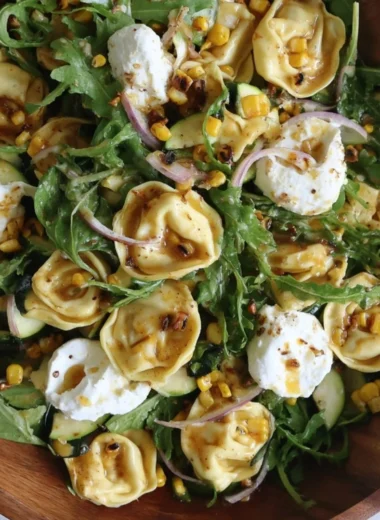Colorful summer tortellini salad with fresh vegetables and herbs.