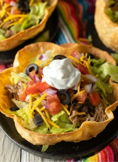 A colorful taco salad bowl filled with fresh toppings and ingredients